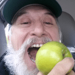 Close up of comedian Frandu as he bites into an apple