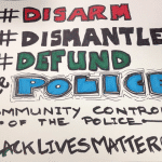 Handmade sign that reads Disarm Dismantle, Defund Police: Community Control of the Police: Black Lives Matter