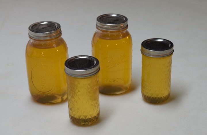 Four bottles of honey with a white background