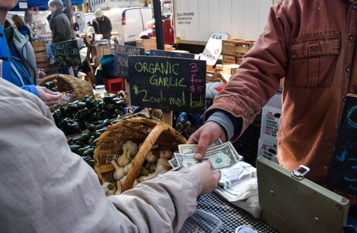 Customer handing Bill dollars at the market