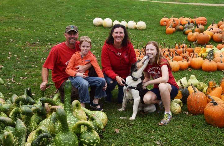Family photo showing farmers, kids, and their dog
