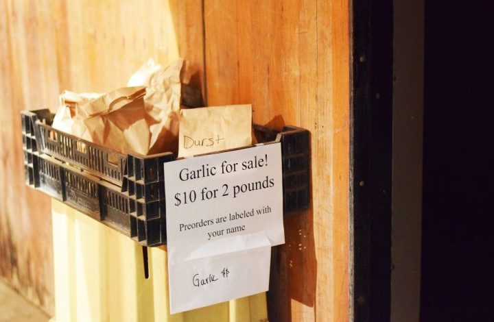 Black farm crate with garlic with sign saying, $10 for 2 pounds